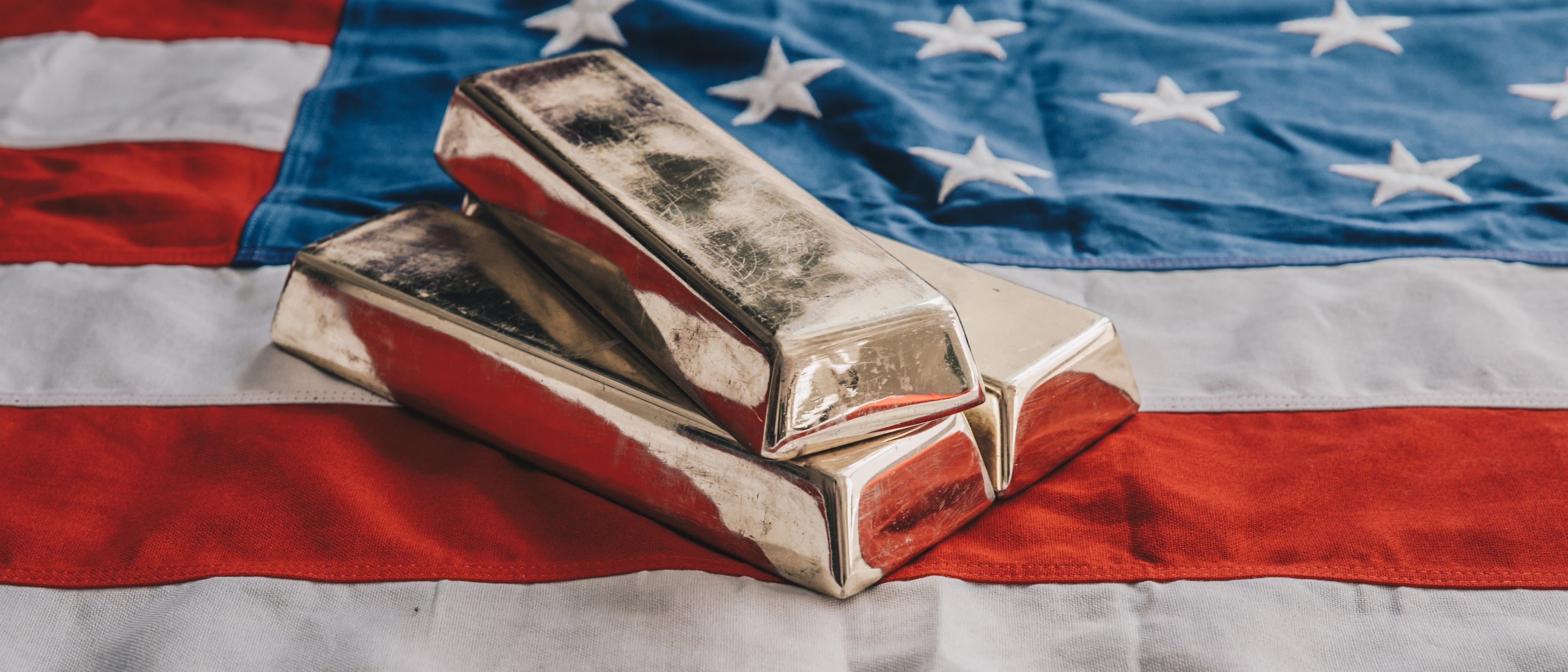 Three gold bars stacked on top of the middle of the American Flag, intersecting between the navy blue and stars inner lower corner and red and white stripes.
